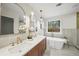 Luxurious bathroom featuring double sinks, soaking tub, elegant fixtures, and a large window with outdoor views at 1788 Piper Se Cir, Atlanta, GA 30316