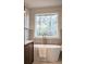 Bright bathroom featuring a soaking tub, a gold faucet, and a serene window view at 1788 Piper Se Cir, Atlanta, GA 30316