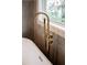 Freestanding tub featuring a modern gold faucet and a window view of the outdoors at 1788 Piper Se Cir, Atlanta, GA 30316