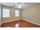 Bedroom features hardwood floors, a ceiling fan, and two windows at 1849 Linnet Ne Ct, Roswell, GA 30075