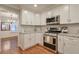 Bright kitchen featuring stainless steel appliances, white cabinets, and hardwood floors at 1849 Linnet Ne Ct, Roswell, GA 30075