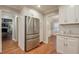 Kitchen featuring stainless steel refrigerator, white cabinets, hardwood floors, and granite countertops at 1849 Linnet Ne Ct, Roswell, GA 30075