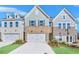 Charming townhome exterior featuring a brick facade and two-car garage at 5619 Tillman Way, Powder Springs, GA 30127