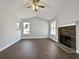 Bright living room featuring hardwood floors, stone fireplace and modern ceiling fan at 99 Cedars Glen Way, Villa Rica, GA 30180
