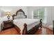 Bedroom with hardwood floors, a decorative bed frame, and a large window with natural light at 1412 Great Shoals Dr, Lawrenceville, GA 30045