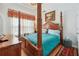 Bedroom featuring a four-poster bed, hardwood floors, and a decorative painting hanging over the bed at 1412 Great Shoals Dr, Lawrenceville, GA 30045