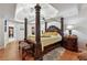 Spacious bedroom with hardwood floors, tray ceilings, a four-poster bed, and stylish decorations at 1412 Great Shoals Dr, Lawrenceville, GA 30045