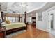 Bedroom featuring a four-poster bed, hardwood floors, tray ceiling and access to additional living space at 1412 Great Shoals Dr, Lawrenceville, GA 30045
