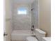 Clean bathroom features white tub with marble-patterned tile surround and bronze fixtures at 2202 Troutdale Dr, Decatur, GA 30032