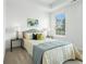 Bright bedroom features a neutral palette, a patterned quilt, and natural light from the window at 2390 Edgar Park Pl # 102, Duluth, GA 30096