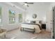 Spacious bedroom with three windows, tray ceiling, neutral tones, and a cozy seating area at 2390 Edgar Park Pl # 102, Duluth, GA 30096