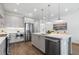 Modern kitchen with an island featuring a sink, stainless steel appliances, light cabinets, and stylish pendant lighting at 2390 Edgar Park Pl # 102, Duluth, GA 30096