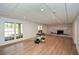 Open basement area with a decorative fireplace, recessed lighting, and large windows at 805 Wesley Oak Rd, Atlanta, GA 30328
