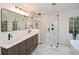 Stylish bathroom with a frameless glass shower, dual vanity sinks, and modern lighting at 805 Wesley Oak Rd, Atlanta, GA 30328