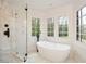 Elegant bathroom with a freestanding tub, marble shower, and large windows at 805 Wesley Oak Rd, Atlanta, GA 30328