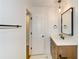 Modern bathroom with white walls, wood vanity, white marble countertop, decorative lighting, and black hardware at 805 Wesley Oak Rd, Atlanta, GA 30328