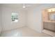 A bright bedroom featuring white walls, a ceiling fan, a window and an ensuite bathroom with gray vanity at 805 Wesley Oak Rd, Atlanta, GA 30328