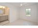 Bright, unfurnished bedroom featuring white walls, a ceiling fan, a window and an ensuite bathroom with gray vanity at 805 Wesley Oak Rd, Atlanta, GA 30328