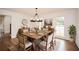 Well-lit dining room featuring hardwood floors, wainscoting, chandelier, and a rustic wooden table with seating for eight at 805 Wesley Oak Rd, Atlanta, GA 30328