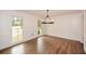 A well-lit dining room with paneled walls, hardwood floors, and large windows bringing the outdoors inside at 805 Wesley Oak Rd, Atlanta, GA 30328