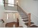 Spacious foyer with staircase, hardwood floors, modern railings and a view of the front entry door and transom at 805 Wesley Oak Rd, Atlanta, GA 30328