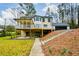 Expansive rear exterior featuring an elevated deck, patio, and stairs ascending towards the attached garage at 805 Wesley Oak Rd, Atlanta, GA 30328