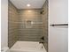 Modern tiled shower and tub with a gray vertically-stacked tile, and updated hardware at 805 Wesley Oak Rd, Sandy Springs, GA 30328