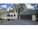 Rear exterior featuring a spacious deck, attached garage, and lush backyard with mature trees at 805 Wesley Oak Rd, Sandy Springs, GA 30328