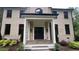 Welcoming front entrance with a classic black door framed by white columns and manicured greenery at 805 Wesley Oak Rd, Sandy Springs, GA 30328