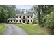 Charming home with a well-maintained front yard, surrounded by lush trees and a paved driveway at 805 Wesley Oak Rd, Sandy Springs, GA 30328