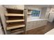 Storage: Custom pantry with pullout drawers, complemented by sleek cabinets, countertops, and hardwood floors at 805 Wesley Oak Rd, Sandy Springs, GA 30328