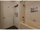 Tiled bathroom featuring a tub and shower combination and a stacked washer and dryer unit at 44 Finch Ne Trl, Atlanta, GA 30308