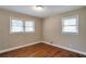 Bedroom featuring hardwood floors, neutral paint, two windows and white trim at 2837 Davidson Dr, Lithonia, GA 30058