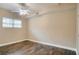 This bedroom features wood flooring, neutral paint, a ceiling fan, and a window at 2837 Davidson Dr, Lithonia, GA 30058