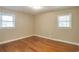 Bedroom featuring hardwood floors, neutral paint, two windows and white trim at 2837 Davidson Dr, Lithonia, GA 30058