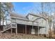 A back exterior featuring multi-level decks, wood siding, and a lush wooded area at 145 Price Hills Ct, Sugar Hill, GA 30518