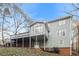 View of the home's back exterior including multi-level decks and a lush, wooded backyard at 145 Price Hills Ct, Sugar Hill, GA 30518