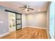 Spacious bedroom with hardwood floors, a ceiling fan, and a sliding barn door to the bathroom at 1659 Olympian Sw Way, Atlanta, GA 30310