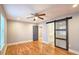 Bedroom with hardwood floors, ceiling fan, and a modern sliding barn door at 1659 Olympian Sw Way, Atlanta, GA 30310