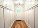 Bright entryway features wood floors, white wainscoting, and stylish wallpaper at 1659 Olympian Sw Way, Atlanta, GA 30310