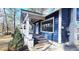 Charming side view of a blue house featuring a welcoming porch with white columns and a blue front door at 1659 Olympian Sw Way, Atlanta, GA 30310