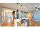 Open-concept kitchen with modern pendant lighting, stainless steel appliances, and hardwood floors at 1659 Olympian Sw Way, Atlanta, GA 30310