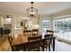 Bright dining area featuring a wooden table, modern lighting, and backyard views at 1742 Dunridge Ct, Dunwoody, GA 30338