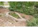 Scenic backyard featuring a winding gravel pathway, mature trees, rock features, and lush landscaping at 180 Winecoff Dr, Fayetteville, GA 30214