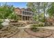 Well-maintained yard with gravel pathways, mature trees, rock features, and a screened-in porch in a beautiful landscaped backyard at 180 Winecoff Dr, Fayetteville, GA 30214
