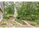 Picturesque backyard featuring a gravel pathway, mature trees, rock features, and manicured landscaping at 180 Winecoff Dr, Fayetteville, GA 30214