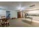Spacious carpeted basement with a kitchenette features white cabinets, stainless steel refrigerator, and an adjacent table at 180 Winecoff Dr, Fayetteville, GA 30214
