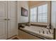 Bright bathroom features a soaking tub with granite surround and plantation shutters at 180 Winecoff Dr, Fayetteville, GA 30214