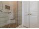 Tiled bathroom with a glass shower door and custom corner shelving for storage at 180 Winecoff Dr, Fayetteville, GA 30214
