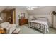 Serene bedroom with natural light, a white iron bed, and a comfortable armchair for relaxation at 180 Winecoff Dr, Fayetteville, GA 30214